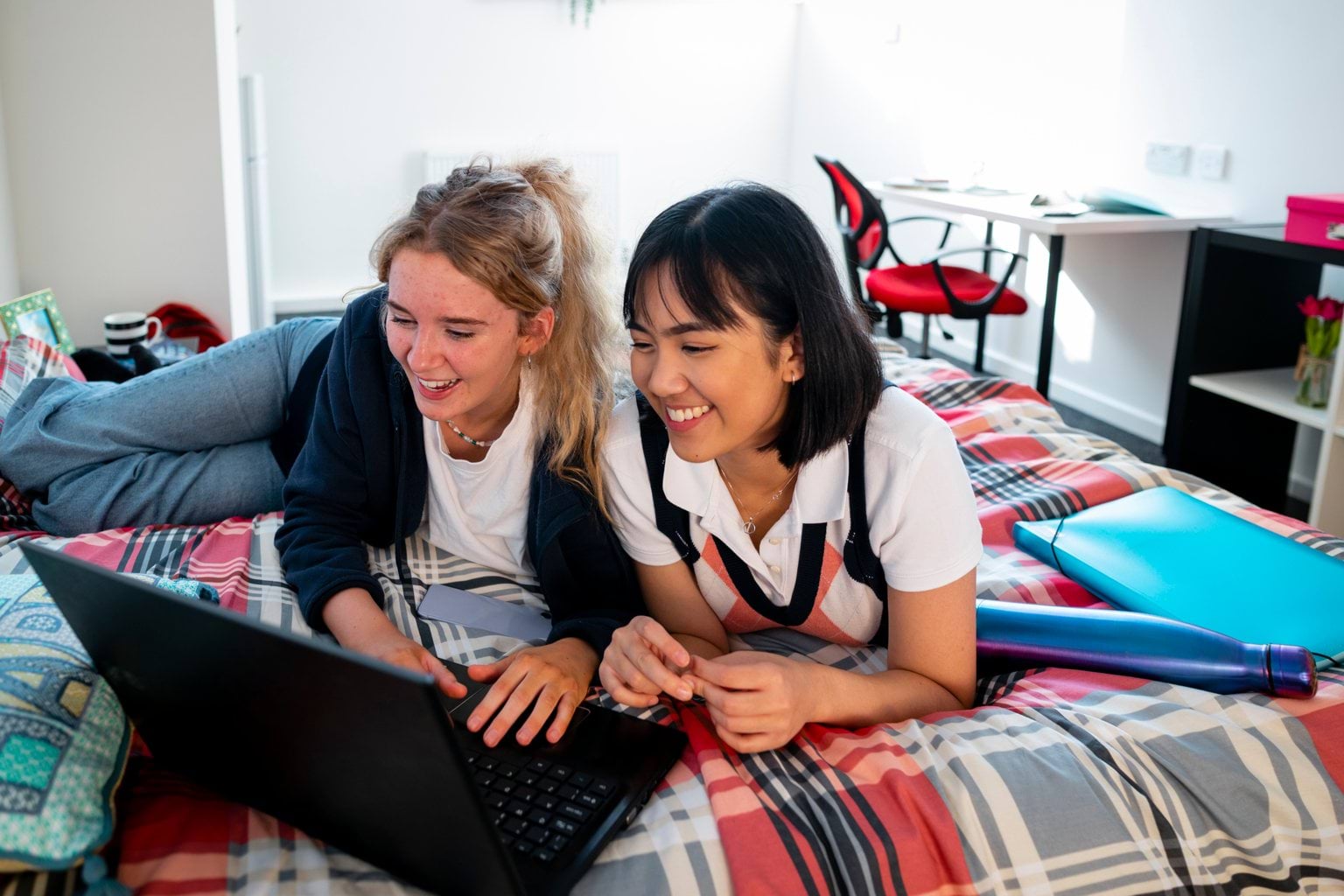 Two students on a laptop in the bedroom of a school boarding premises